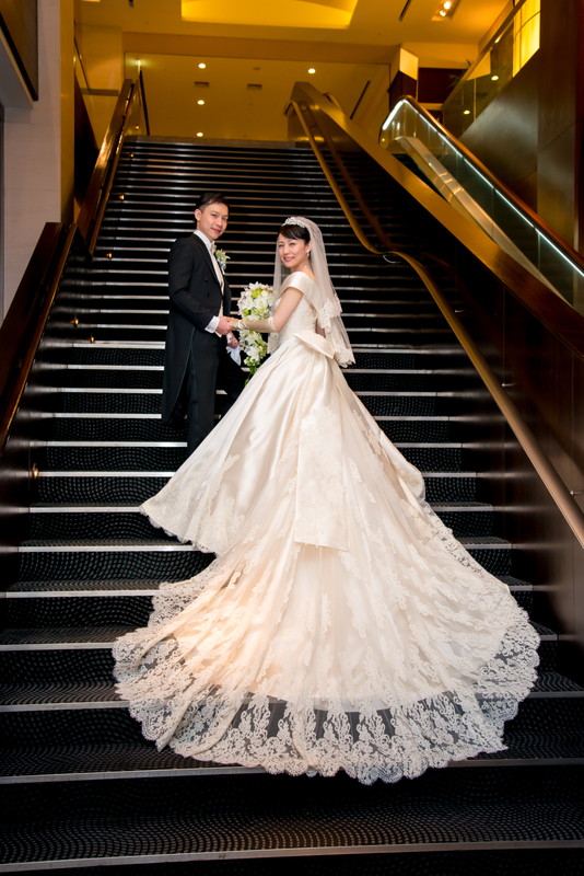 美しいロングトレーンのドレスは、階段でも素敵なお写真を残せるのも魅力の1つ。バージンロードでもの存在感があり、ゲストの羨望を集める写真を残せる。